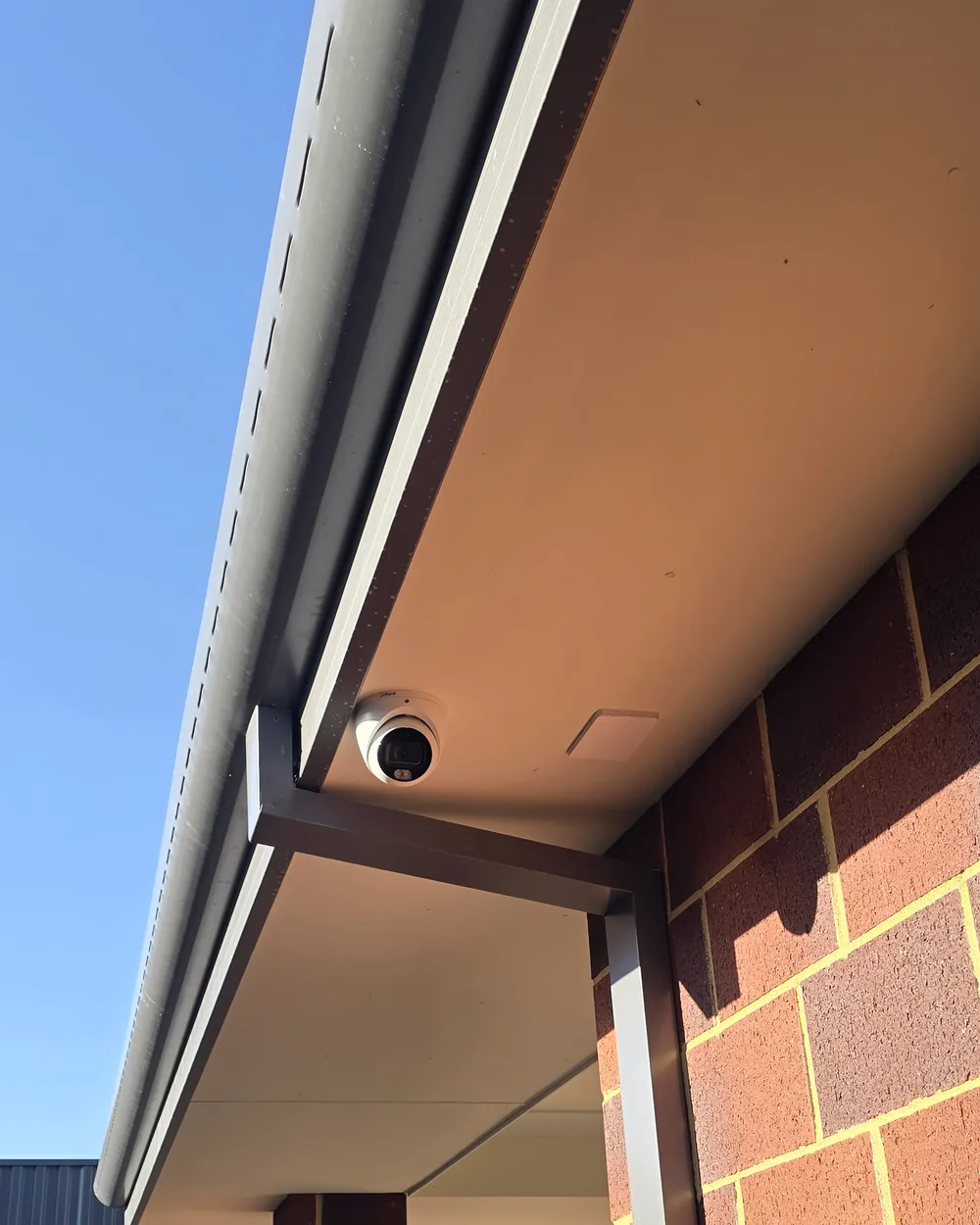 Dahua camera brought forward under the eave Dahua turret camera positioned forward under a wide eave on a red brick home